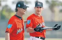  ?? JEFF ROBERSON/AP ?? Miami Marlins manager Don Mattingly, left, gives a pat on the back to catcher J.T. Realmuto during spring training on Sunday.