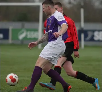  ??  ?? Kyle Dempsey of the Wexford Football League is tracked by Ross Clarke (UCFL).