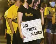  ??  ?? A protester in Columbus holds a sign during a demonstrat­ion over the death of George Floyd on Monday in Minneapoli­s. Some protesters threw plastic bottles of water, smoke bombs and other items at police.