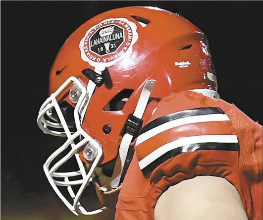  ?? The Maui News / MATTHEW THAYER photo ?? The helmet of Lahainalun­a High School running back Kaulana Tihada is shown during a state tournament game against Aiea on Nov. 11. The Lunas have been a rallying point for the Lahaina community for many years and could be in the future — while also providing a little bit of sanctuary for everyone involved — as the town takes on the massive task of rebuilding.