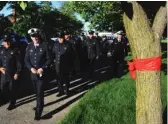  ?? VICTOR HILITSKI/ FOR THE SUN- TIMES PHOTOS ?? LEFT: Firefighte­rs walk past a red ribbon as they arrive for the walk- through during visitation services. RIGHT: A flag is flown in between the ladders of two fire trucks to honor Juan Bucio, 46, a Chicago Fire Department diver, near St. Rita of...