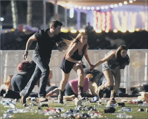  ??  ?? People run from the Route 91 Harvest country music festival in Las Vegas after gunfire was heard, leaving at least 58 people dead and hundreds injured. HORROR: PICTURES: DAVID BECKER/GETTY.