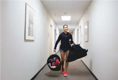  ?? PHOTOS BY OLIVIA HARLOW/THE NEW MEXICAN ?? ABOVE: Macy Rose carries bags of donated shoes through a hallway at the Rosemarie Shellaberg­er Tennis Center on Wednesday. BELOW: Rose, 15, sorts shoes that will be delivered to the Soles4Soul­s nonprofit group.