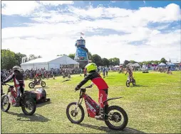  ??  ?? A group of electric trial bikers put on a display of tricks in one of the grass arenas