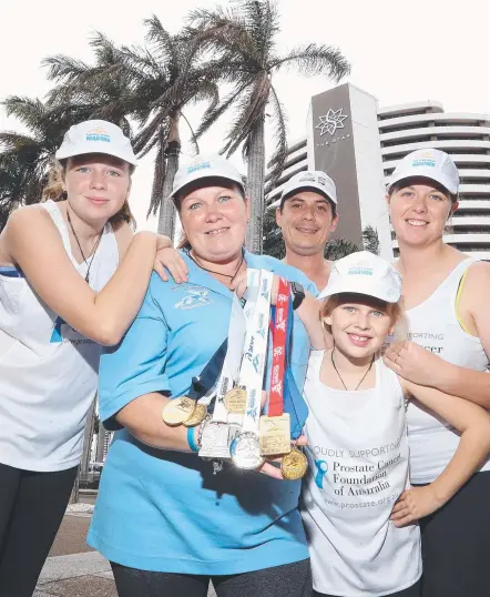  ??  ?? Vanessa Hogan (in blue) holds medals awarded to her father Les Blake, an avid marathon runner who recently died of prostate cancer. Vanessa and family Kaelani Hogan (13), Adam Blake, Tamsyn Hogan (10) and Abby Blake will honour Les by taking part in...