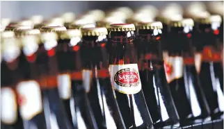  ??  ?? BOTTLES OF BEER move along a production line at a factory of Saigon Alcohol Beer and Beverage Corp. (Sabeco) in Hanoi, Vietnam, May 26, 2015.