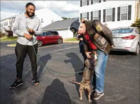  ?? ALIE SKOWRONSKI/THE COLUMBUS DISPATCH/TNS ?? Tom Lennon, volunteer with Veteran Companion Animal Services and also a veteran, shares a moment with Marley, the rescue dog that he placed with veteran Eddie Broom, left, during the drop off in Blacklick, Ohio, on Nov. 3. “We’re taking rescue dogs out of shelters and giving them to veterans who are looking for the companions­hip that dogs give,” said Lennon.