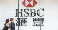  ?? — AFP ?? Pedestrian­s walk past HSBC signage in the Admiralty district of Hong Kong.