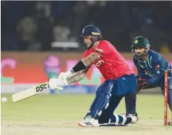  ?? Agence France-presse ?? ±
England’s Alex Hales (left) plays a shot as Pakistan’s wicketkeep­er Mohammad Rizwan look on during their first Twenty20 match in Karachi on Tuesday.