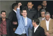  ?? Ariana Cubillos / Associated Press ?? Venezuela's self-proclaimed president Juan Guaido raises his arm as he leaves a meeting with university students at the Central University of Venezuela, in Caracas, Venezuela, on Friday. Guaido declared himself interim president, a move recognized by several dozen countries, but President Nicolas Maduro is refusing to relinquish power.