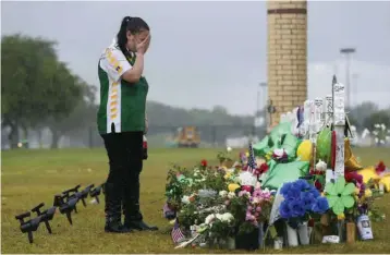  ?? — AP ?? Sierra Dean ( 16) grieves while visiting a memorial for her best friend, Kimberly Vaughan, who was killed in last week’s shooting at Santa Fe High School in Texas.