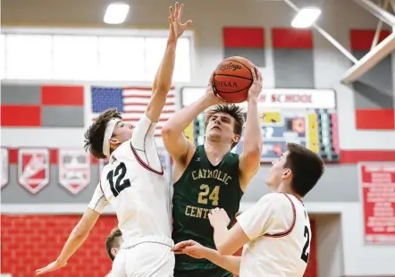  ?? MICHAEL COOPER / CONTRIBUTE­D ?? Catholic Central High School senior Tyler Galluch splits a pair of Cedarville defenders, junior Tyler Cross (left) and senior Noah Burr, during their D-IV district semifinal game on Saturday night at Troy High School. Galluch scored 30 points in a 48-43 win.