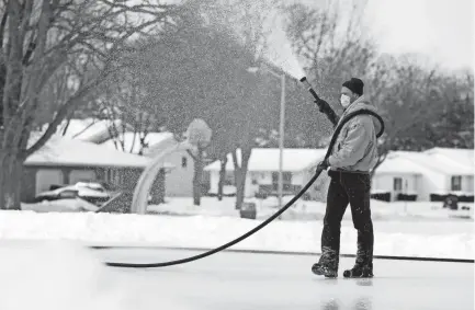  ?? SARAH KLOEPPING/USA TODAY NETWORK-WISCONSIN ?? Jeff Paape, Green Bay Parks, Recreation and Forestry Department employee, makes a fresh layer of ice on the skating rink at Perkins Park on Feb. 18 in Green Bay.