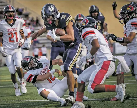  ?? PHOTOS BY JIM WEBER/THE NEW MEXICAN ?? Demons running back Martell Mora, center, plows through Cardinals defenders for a touchdown during the Aug. 20 season opener against Las Vegas Robertson at Ivan Head Stadium.