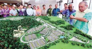  ??  ?? ... Sultan of Johor Sultan Ibrahim Iskandar, flanked by Astaka Holdings Limited (Astaka) founder Datuk Daing A Malek A Rahaman (third from right) and CEO Datuk Zamani Kasim (second from right), looks at the strata township developmen­t model during the...