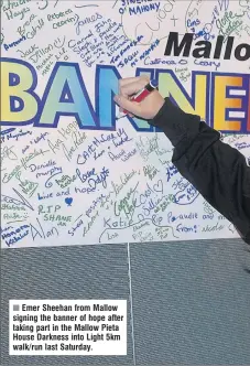  ??  ?? Emer Sheehan from Mallow signing the banner of hope after taking part in the Mallow Pieta House Darkness into Light 5km walk/run last Saturday.