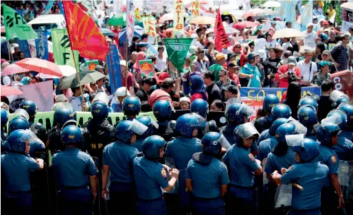  ?? AFP ?? Policemen in riot gear stand in formation as protesters attempt a march on the US embassy in Manila on Monday, during the 50th Associatio­n of South-east Asian Nations (Asean) regional security forum being held in the city. —