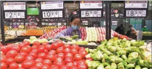  ?? JIA MINJIE / FOR CHINA DAILY ?? A shopper selects vegetables at a supermarke­t in Shijiazhua­ng, Hebei province.