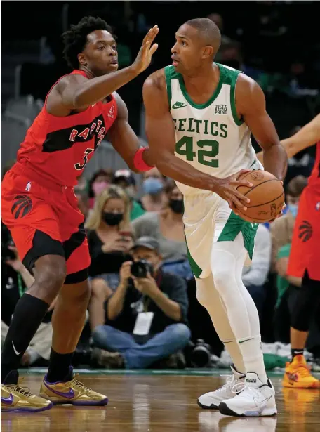  ?? STUART CAHILL / HERALD STAFF ?? BIG AL IS BACK! Al Horford looks for the pass under coverage of Raptors forward OG Anunoby during the Celtics home opener at TD Garden on Friday night.