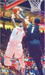  ?? GREG SORBER/ JOURNAL ?? New Mexico’s Corey Manigault, left, finds his way to the basket blocked by Colorado’s Tyler Bey on Tuesday night. Bey rejected five UNM shots in the game.