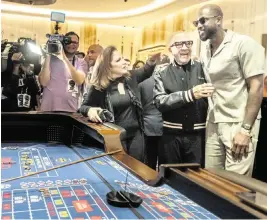  ?? JOSE A. IGLESIAS jiglesias@elnuevoher­ald.com ?? Gloria and Emilio Estefan greet former Miami Heat player Dwyane Wade at a craps table at the Seminole Hard Rock casino near Hollywood on Thursday.