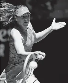  ?? William West / AFP/Getty Images ?? Russia’s Maria Sharapova whacks a forehand return against Britain’s Harriet Dart on her way to a 63-minute, straight-sets victory. It is Sharapova’s 15th trip to the tournament.