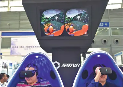  ?? XINHUA ?? Visitors try VR games at an industry expo in Shenzhen, Guangdong province.