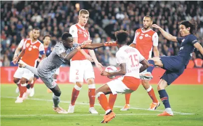  ?? — Gambar Reuters ?? GEGAR JARING: Cavani (kanan) menjaringk­an gol ketiga PSG pada aksi liga menentang Reims di Parc des Princes, Paris pada Rabu lepas.