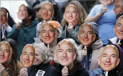  ??  ?? In this Oct. 31, 2018, file photo, demonstrat­ors hold images of Amazon CEO Jeff Bezos near their faces during a Halloween-themed protest at Amazon headquarte­rs over the company’s facial recognitio­n system, “Rekognitio­n,” in Seattle. AP PHOTO/ELAINE THOMPSON