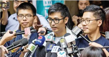  ??  ?? Wong (left), Chow (centre) and Law (right) speak to the press outside the Court of Final Appeal after the first hearing in their bid to appeal their jail sentences in Hong Kong. — AFP photo