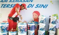  ?? FRIZAL/JAWA POS ?? STOK CUKUP: Pegawai Pertamina menata BBM dalam kemasan kaleng di kantor Pertamina, Jagir, Surabaya, kemarin (30/05).