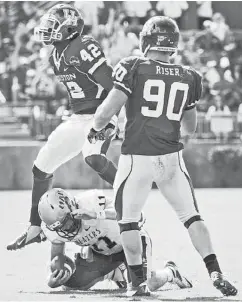  ?? Smiley N. Pool / Houston Chronicle ?? UH’s Phillip Steward ( 42) and Zeke Riser ( 90) celebrate Steward’s sack of UAB’s Austin Brown.