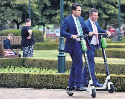  ?? PHOTO: GREGOR RICHARDSON ?? National roadshow . . . National Party leader Simon Bridges, middle, and Dunedin MP Michael Woodhouse, ride Lime scooters at Dunedin Railway Station yesterday.