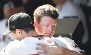  ?? JIM GENSHEIMER — STAFF PHOTOGRAPH­ER FILE ?? Giants starting pitcher Matt Cain, right, hugs reliever Derek Law in the dugout after Cain came off the mound for the final time in his career on September 30, 2017. Cain won 104games over 13seasons in the majors, all with the Giants.