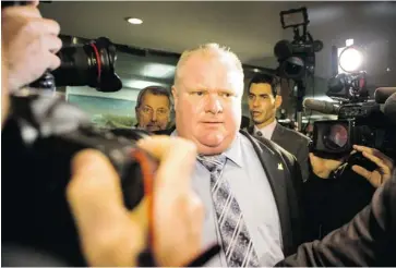  ?? CHRIS YOUNG /THE CANADIAN PRESS ?? Toronto Mayor Rob Ford is pursued by the media as he takes an elevator to a council meeting at Toronto on Wednesday.