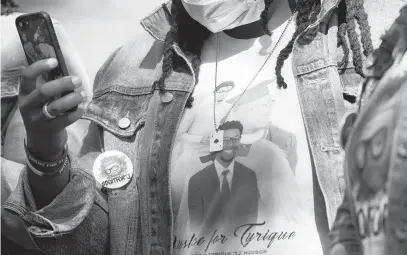  ?? BRIAN KRISTA/CAPITAL GAZETTE ?? A woman wears a button and shirt of Glen Burnie shooting victim Tyrique Hudson in front of the Anne Arundel County Courthouse.