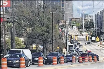  ?? ROSALIND BENTLEY / RBENTLEY@AJC.COM ?? A vision of things to come: the view northbound on Piedmont Road Friday shows a column of cars crawling south and three empty lanes northbound.