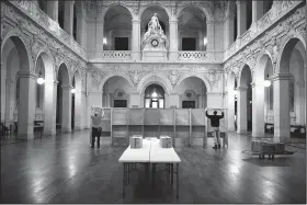  ?? AP/LAURENT CIPRIANI ?? Workers prepare voting booths Saturday at a polling station in Lyon in central France for the first round of the presidenti­al election.