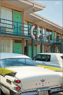  ?? NATIONAL CIVIL RIGHTS MUSEUM ?? Vintage cars from the 1960s sit parked beneath the motel balcony on which the Rev. Martin Luther King Jr. was standing when he was assassinat­ed 50 years ago, in 1968. The National Civil Rights Museum surrounds the old motel.