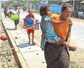  ?? ?? On the run: Families fleeing after a monastery sheltering displaced civilians was attacked by a regime warplane in Karen state. — ap