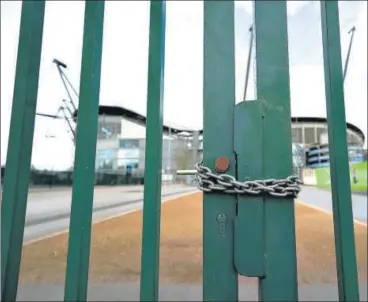  ?? AP PHOTO ?? A locked gate at the Etihad Stadium in Manchester symbolises the impact of the coronaviru­s on Premier League football.