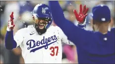  ?? MARCIO JOSE SANCHEZ/AP ?? LOS ANGELES DODGERS’ TEOSCAR HERNÁNDEZ (left) has sun ower seeds tossed at him after his solo home run during the fourth inning of a game against the San Francisco Giants on Monday in Los Angeles.