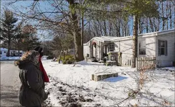  ?? Will Waldron / Times Union ?? Kristina Hardy Allen and her husband look across the street at the abandoned trailer home near their house on Thursday at Malta Gardens in Mechanicvi­lle.