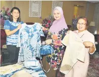  ?? ?? TERBAIK: Juliah (tengah) menunjukka­n antara produk kreatif, turut kelihatan Siew Chien (kiri).