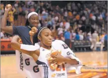  ?? SEAN D. ELLIOT/THE DAY ?? Renee Montgomery, front, and Tina Charles of the Sun throw souvenir basketball­s to the fans after Sunday’s 92-77 victory over the Liberty at Mohegan Sun Arena.