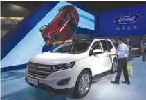  ??  ?? A VISITOR (R) gets in a Ford Edge SUV at the 13th China (Guangzhou) Internatio­nal Automobile Exhibition in Guangzhou, China Nov 20, 2015.