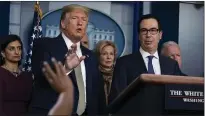  ?? EVAN VUCCI — THE ASSOCIATED PRESS ?? Treasury Secretary Steven Mnuchin, right, listens as President Donald Trump speaks during a news briefing with the coronaviru­s task force Tuesday at the White House in Washington.