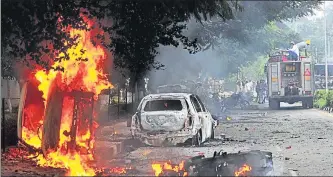  ?? RAVI KUMAR/HT ?? Dera followers set vehicles on fire in Panchkula after a CBI court held their chief Gurmeet Ram Rahim Singh guilty in a rape case on Friday. A mob burnt the twowheeler of the HT photojourn­alist who clicked this picture.