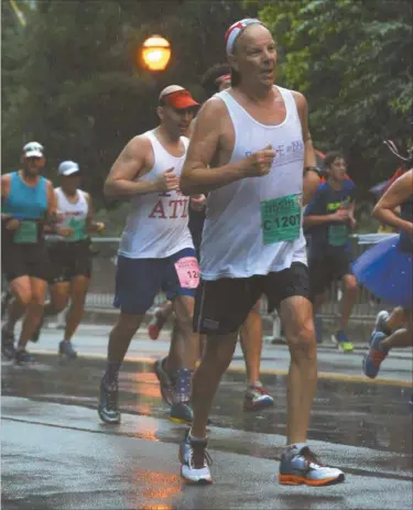  ??  ?? Polk County runner Larry Kuglar competed in his 40th Peachtree Road race this year.