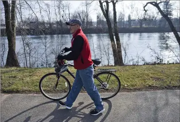  ?? BEN HASTY — MEDIANEWS GROUP ?? John Wolfe, a Schuylkill River Trail Ambassador on the trail with his bike. At Riverfront Park in Pottstown. The Schuylkill River Trail runs through the park.